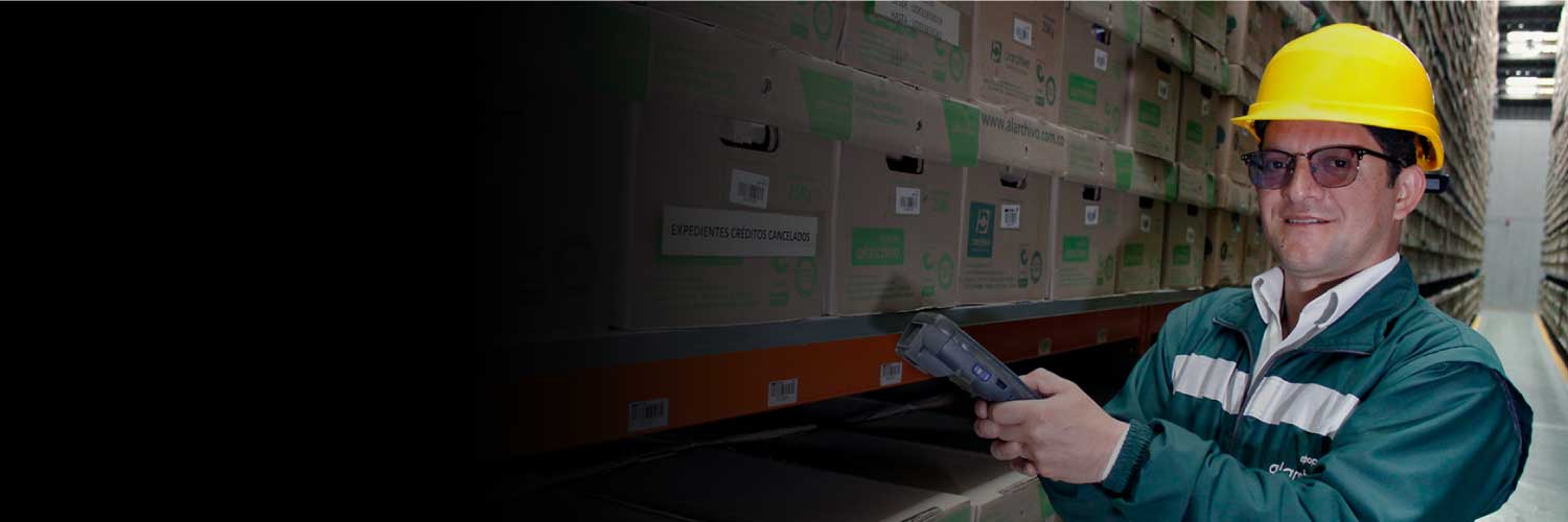 Un hombre sosteniendo un lector de codigos mientras escanea las cajas al interior de un almacén