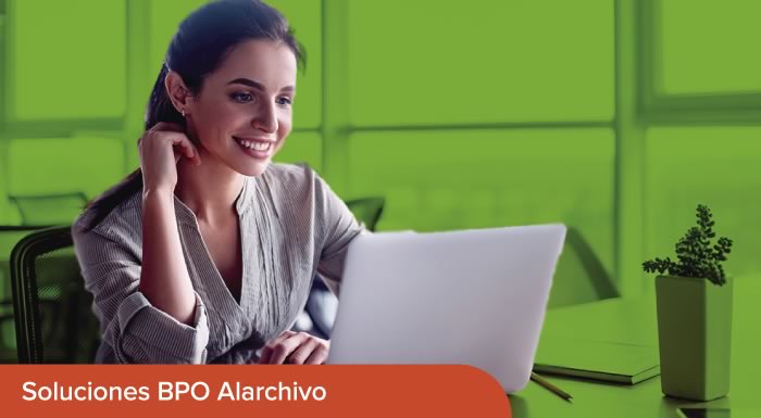 Mujer sonriendo mientras observa su computador 