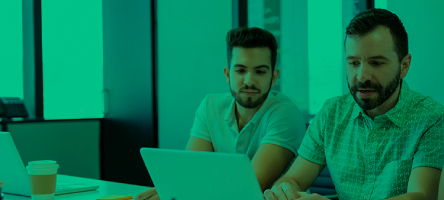 Blog de noticias Dos hombres sentados observando un portátil